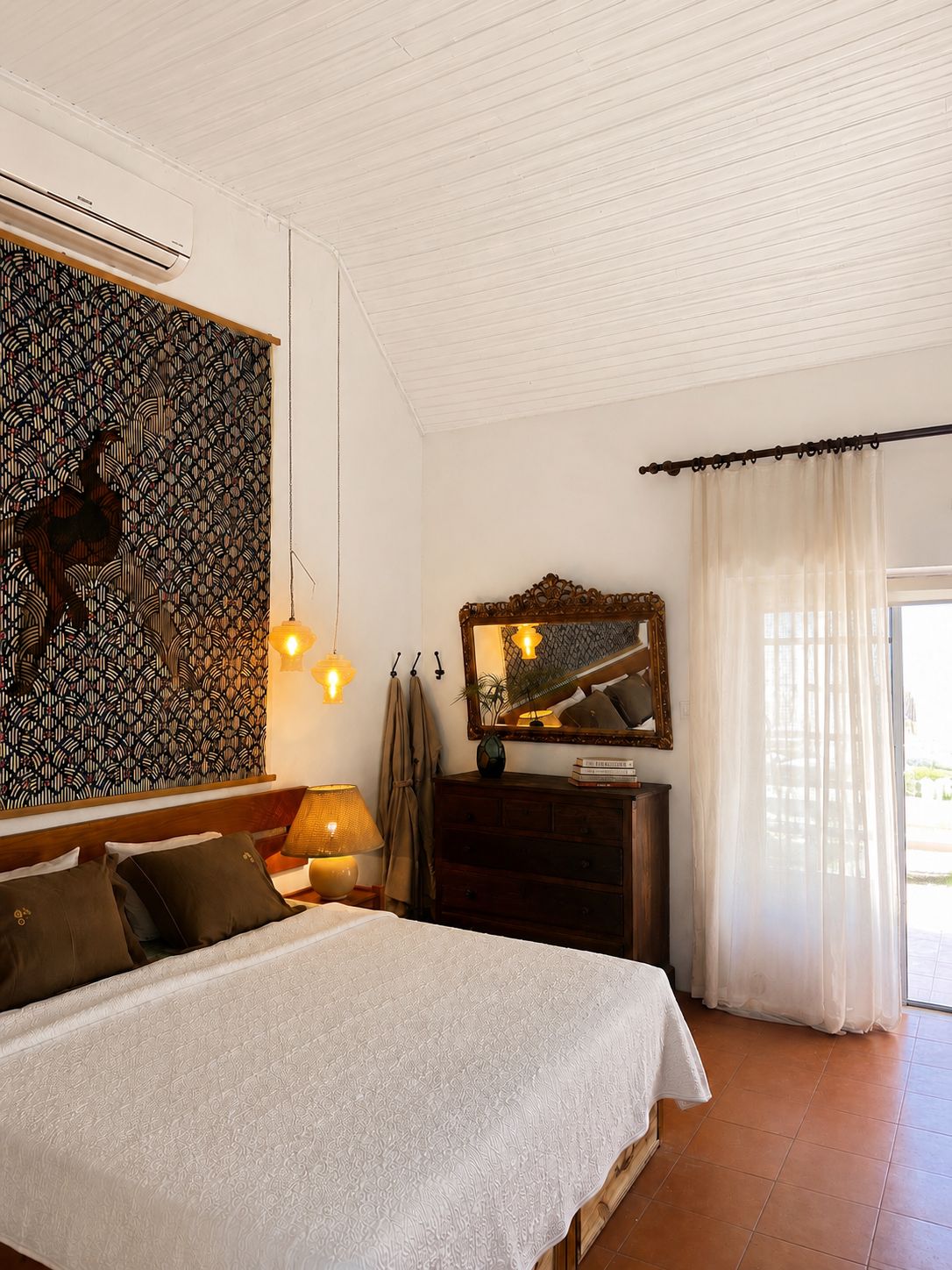 Quarto da villa com cama de casal e porta para o jardim