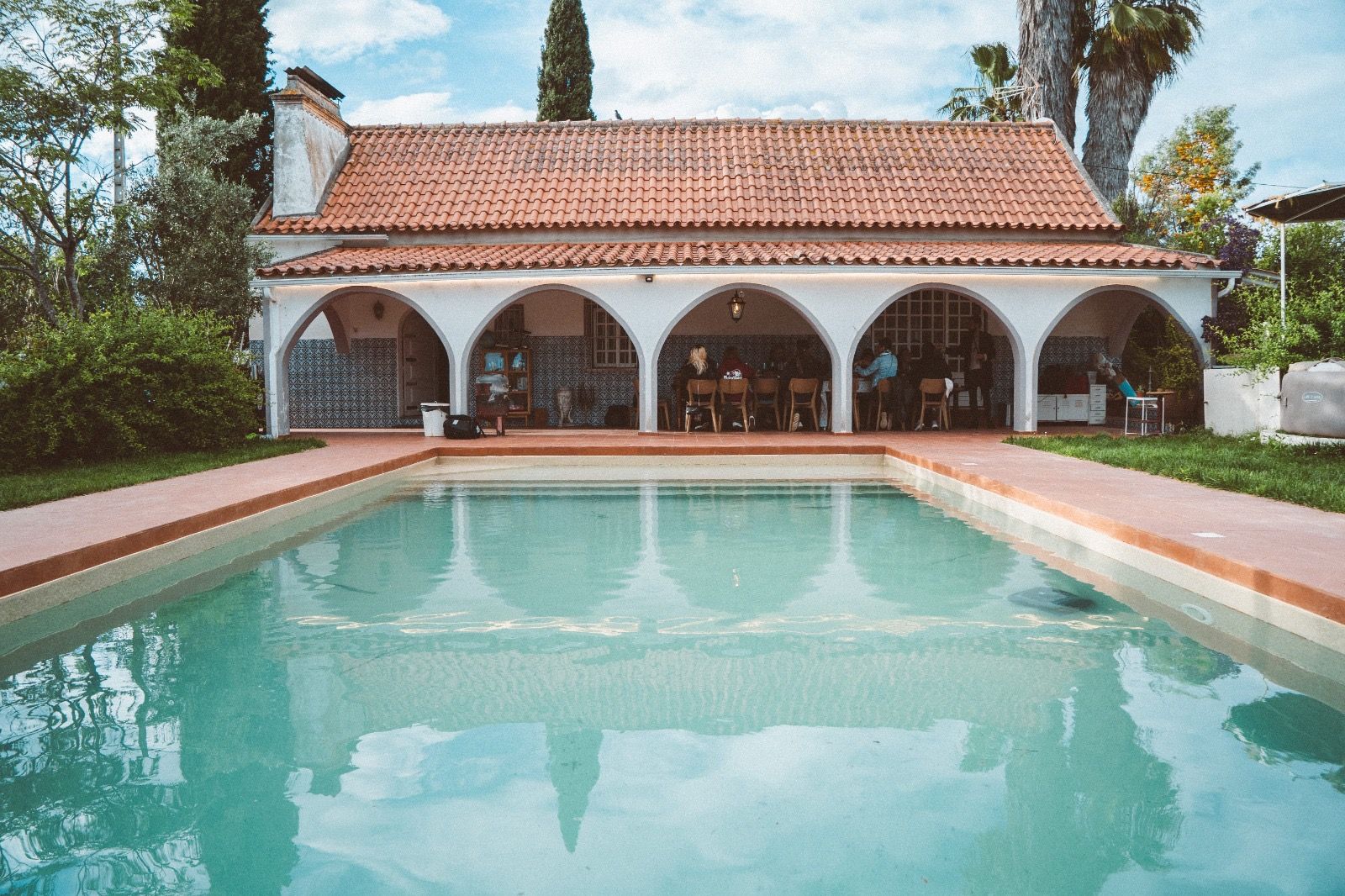 Piscina e alpendre com arcos